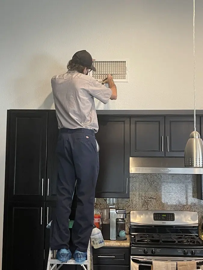 Technician inspecting an air vent during HVAC service in Ladson